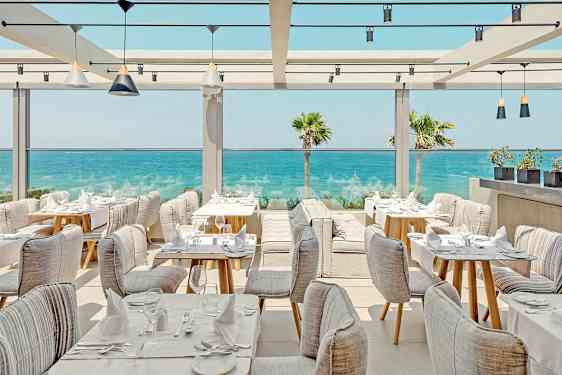 En restaurant med sitteplasser ved havet. (AI-generert tekst)