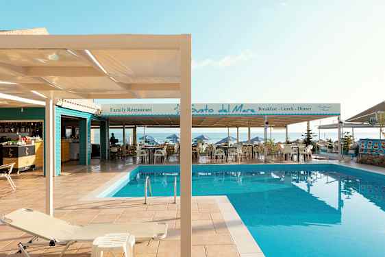 Bilde av et basseng ved en terrasse med restauranter ved havet. (AI-generert tekst)