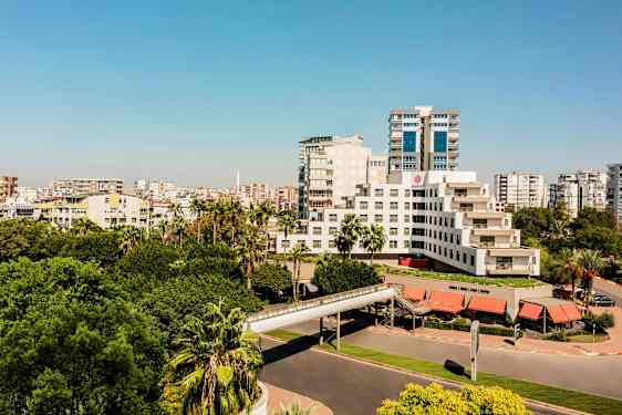 En moderne bygning omgitt av frodige trær og bymiljø. (AI-generert tekst)