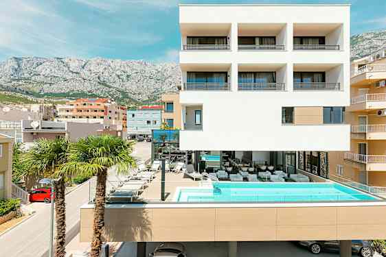 Moderne bygning med basseng og palmer foran. (AI-generert tekst)