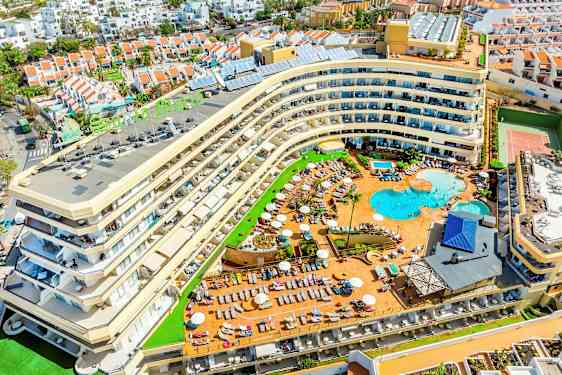 Bilde av et hotell med bassengområde og omkringliggende ferieboliger. (AI-generert tekst)