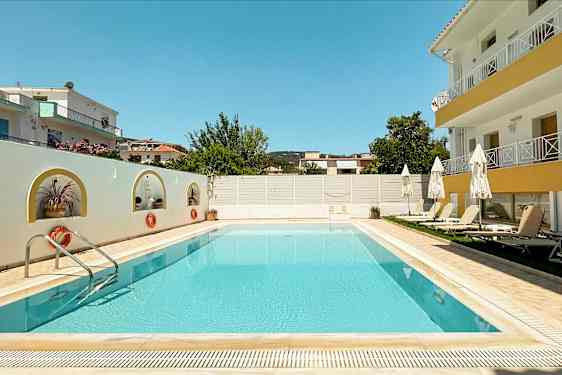 Bilde av et utendørs svømmebasseng omringet av solsenger og bygninger. (AI-generert tekst)