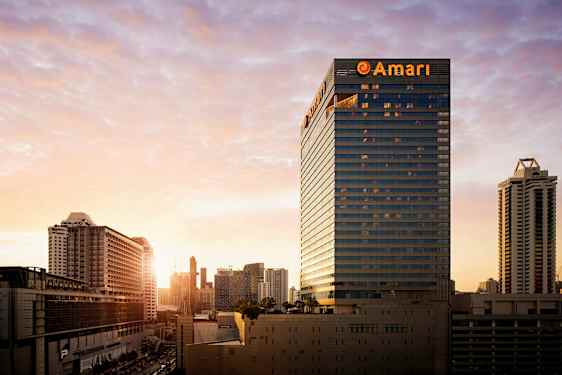 En byutsikt ved solnedgangen med høye bygninger og strukturer dominerer landskapet. (AI-generert tekst)