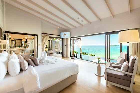 Et lyst hotellrom med utsikt over havet. (AI-generert tekst)