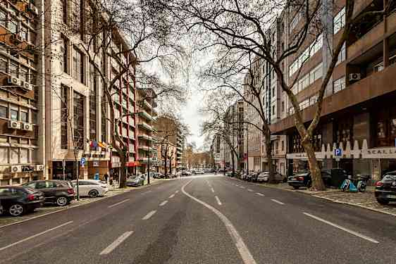 Et bilde av en tom bygate omgitt av bygninger og trær. (AI-generert tekst)