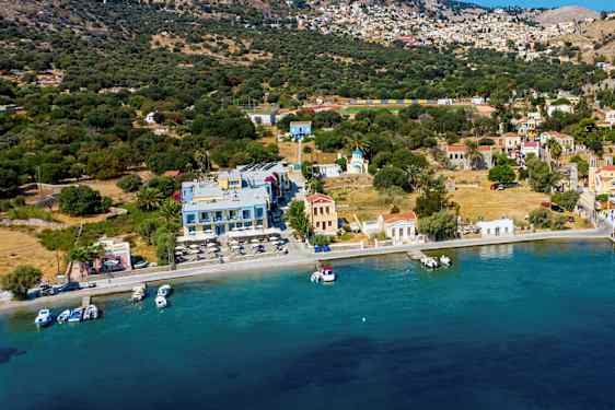 Havnemiljø ved en liten kystby i Middelhavet med små båter ved bryggen. (AI-generert tekst)