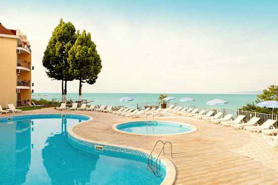 To bassenger med solsenger og parasoller på et sted nær sjøen. (AI-generert tekst)