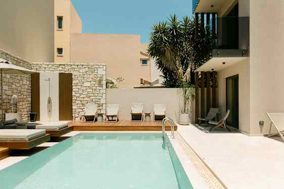 Utendørsbasseng og solsenger ved en moderne bygning. (AI-generert tekst)