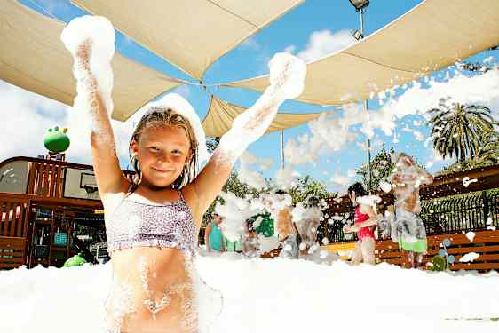 En gruppe mennesker nyter en skummende aktivitet under et skjermtak utendørs. (AI-generert tekst)