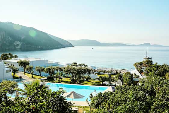 En ferieanlegg ved sjøen med basseng og grøntområde. (AI-generert tekst)