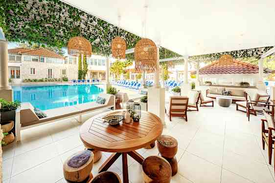 Bassengområde med sittgrupper og utsikt over vann. (AI-generert tekst)