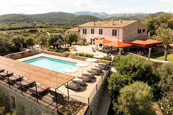 En villa med basseng og terrasse omgitt av grøntområder og åser. (AI-generert tekst)