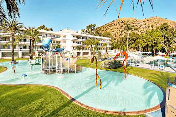 Barnebasseng med vannlek og hotellbygning i bakgrunnen. (AI-generert tekst)