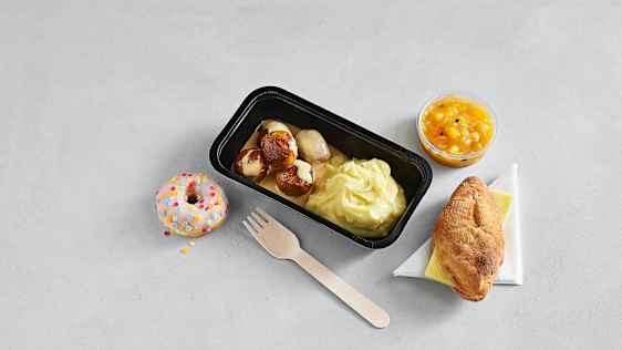 Kjøttboller med potetmos, frukt, brød med ost og en donut. 