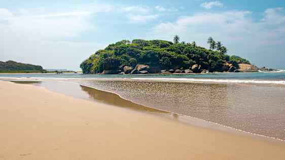 Strand med ö i bakgrunden på Sri Lanka
