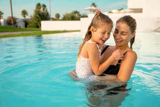 Mamma och dotter i en pool