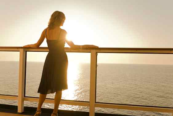 En dame ser utover havet fra et cruiseskip