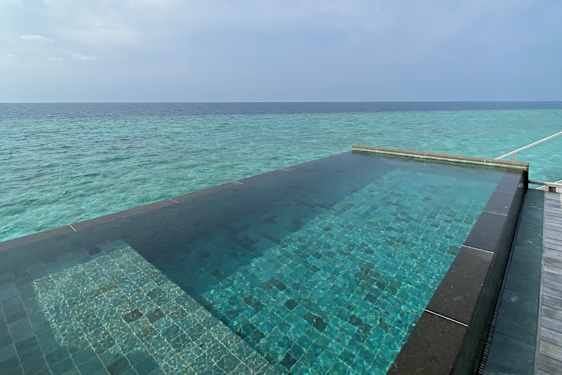 Basseng som strekker seg ut i det turkisblå havet