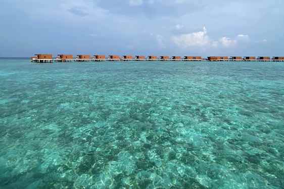Water villas ligger på rekke over det turkisblå havet