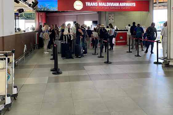 Folk står i kø på en liten flyplass