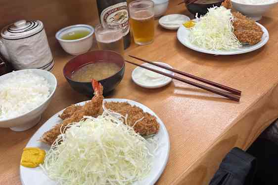 Saftig, fritert svin og scampi, servert med finstrimlet kål, ris, og tonkatsu-saus