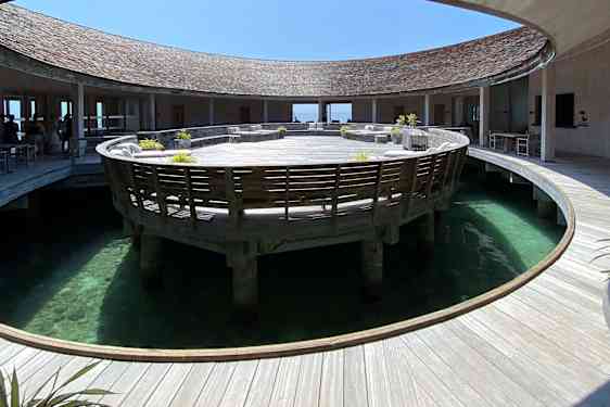 Rund trebygning med en sirkelformet åpning mot havet i midten