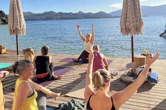 Yoga med Masse påfyll av D-vitamin på brygge ved siden av havet