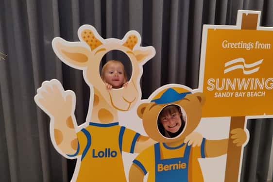 Mor og datter kikker ut gjennom Lollo & Bernie-pappfigur