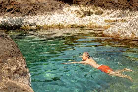 Mann svømmer i en lagune på Tenerife