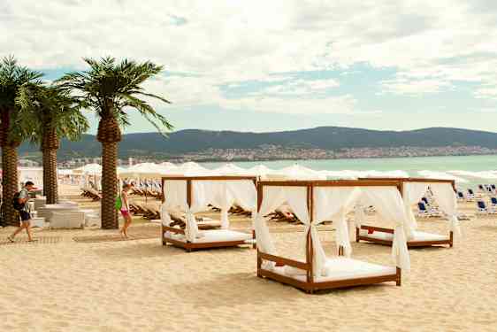 Strand med solstoler og parasoller