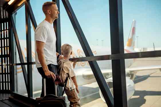 Pappa och son tittar på ett flyglan