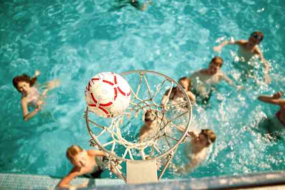Ungdom spiller basket i bassenget