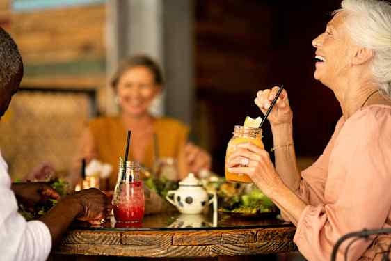 Tre personer nyter drikke ved et bord