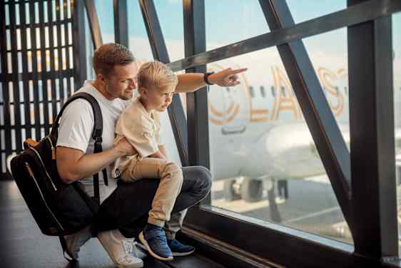 Far og sønn ser på fly
