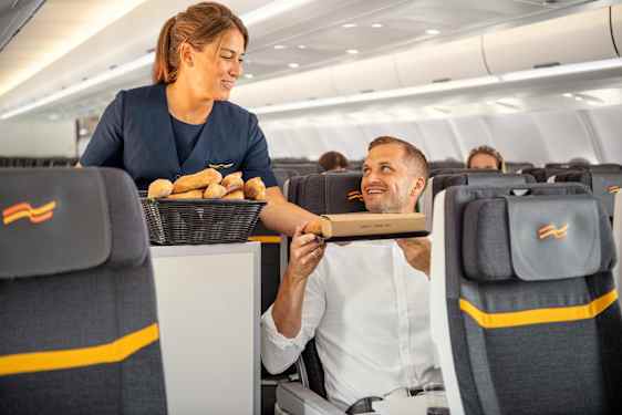 Flyvertinne serverer mat til gjest om bord på Sunclass Airlines
