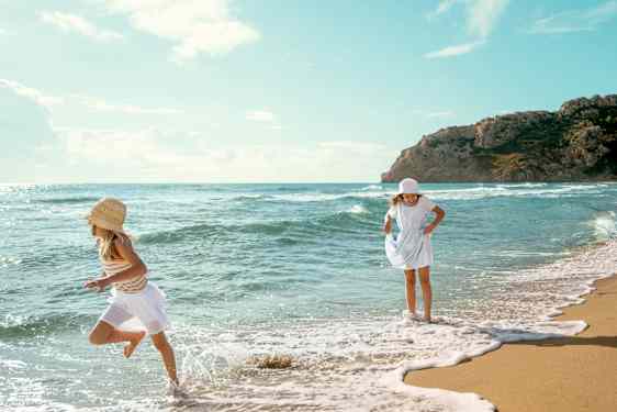 To glade jenter leker på stranden på Sunwing Bangtao