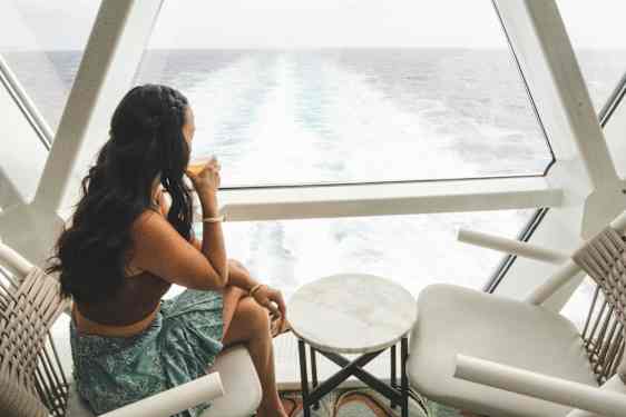 Kvinne ser ut på havet fra akterenden av et skip
