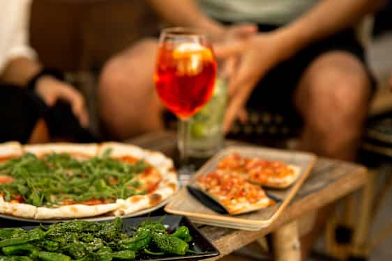 Pizza og et glass med vin på et bord