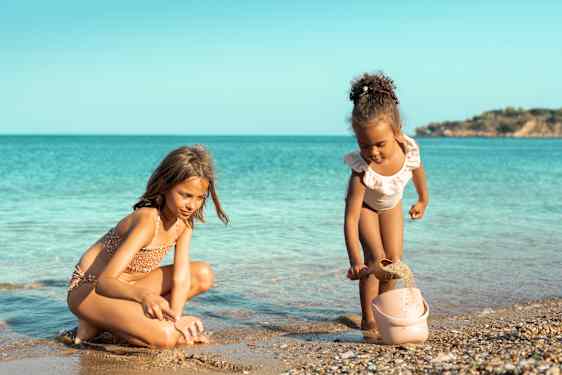 To jenter leker på en strand