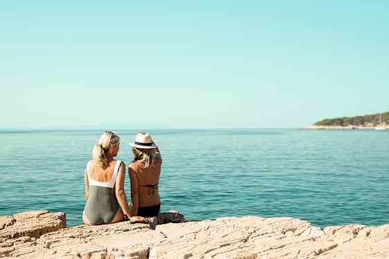To venninner på sommer ferie, de sitter på et svaberg og speider utover havet