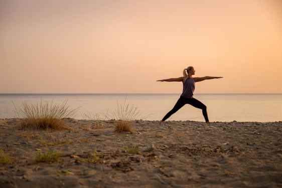 Kvinne i yoga posisjon på stranden