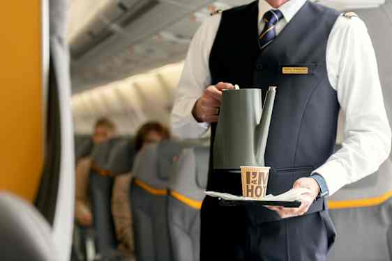 Flyvertinne serverer mat til gjest om bord på Sunclass Airlines