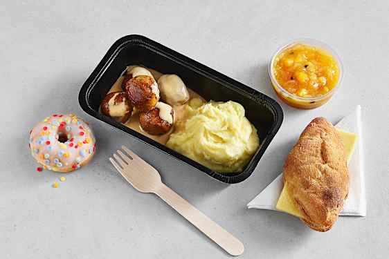 Kjøttboller med potetmos, frukt, brød med ost og en donut. 