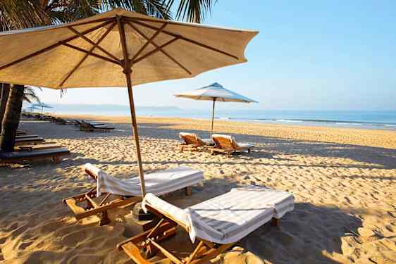 Solsenger på en strand i Goa