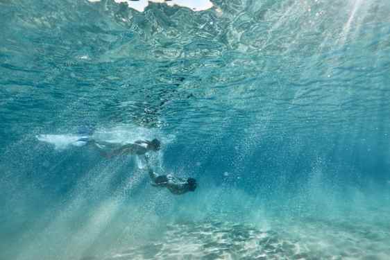 Mann og kvinne som fridykker under overflaten