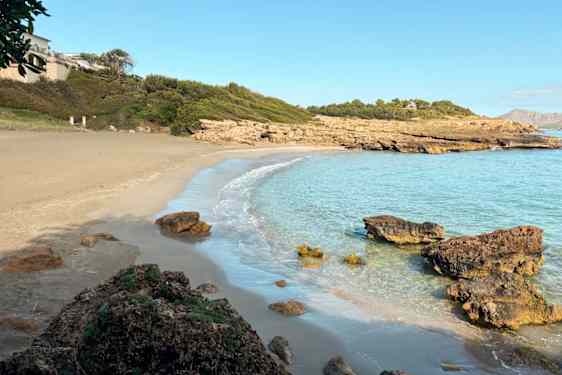 Bukt med sandstrand og klipper