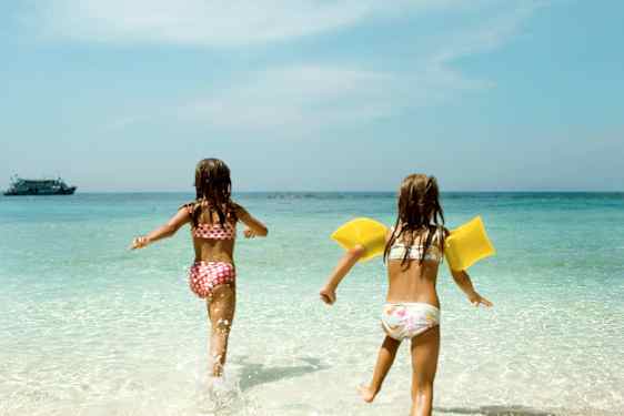 To barn springer ut på en strand i Thailand