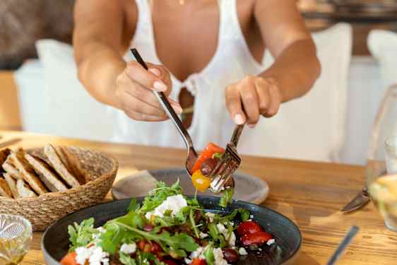 Kvinne forsyner seg av gresk salat