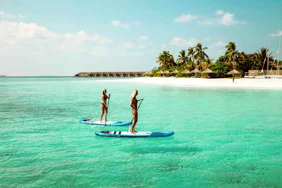 To personer på paddleboard på en øy i Maldivene