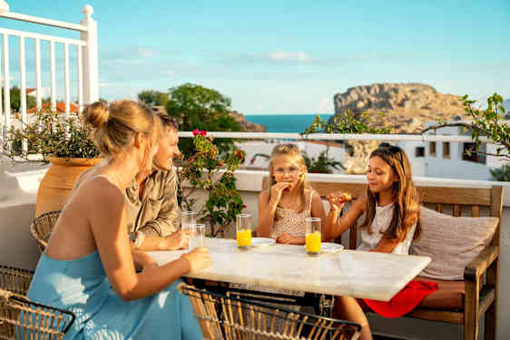 Familie koser seg på en restaurant med utsikt over vannet.